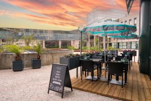 a restaurant with tables and chairs and an umbrella at Vila Gale Porto - Centro in Porto