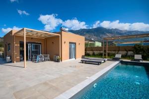a villa with a swimming pool and a house at MENTOROS VILLAS in Karavádhos