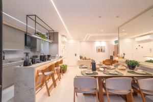 a kitchen and dining room with a table and chairs at Apartamento em Condomínio Frente-Mar com Piscinas, Jacuzzi Aquecida, Sauna, Academia, Brinquedoteca, Churrasqueira na Sacada, Cozinha Completa in Piçarras