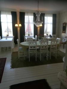 a dining room with a table and chairs and a chandelier at Hotell Floras Trädgård in Öregrund