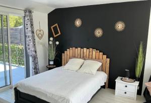 a bedroom with a bed and a black wall at Les Terasses d Eole in Assigny