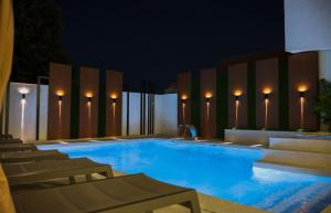 a large swimming pool at night with chairs and lights at Hotel San Međugorje in Čitluk