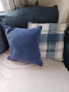 a blue pillow sitting on top of a bed with pillows at Ruby'scumbrianholidaysforall SEN friendly in Carlisle +12 photos