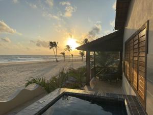 a house on the beach with a swimming pool at Hotel Rede Beach in Trairi
