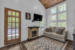 a living room with a couch and a fireplace at Menlo GA Tiny Home Experience in Rising Fawn