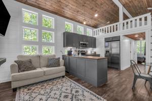 a living room with a couch and a kitchen at Menlo GA Tiny Home Experience in Rising Fawn