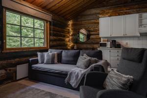 a living room with a couch in a log cabin at Rukan Lumikelo in Kuusamo