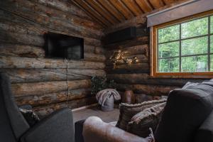 a living room in a log cabin with a television at Rukan Lumikelo in Kuusamo