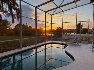 a swimming pool in a house with a view of the sunset at Villa With Private Pool, and Lake Views in Davenport