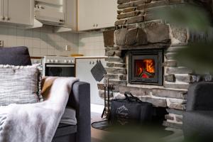 a living room with a stone fireplace in a kitchen at Rukan Lumikelo in Kuusamo +23 photos