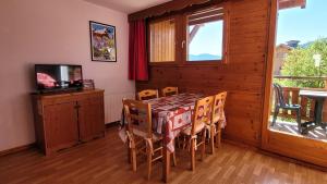 a dining room with a table and chairs and a television at Sunny chalettt great view ski in Puy-Saint-Vincent