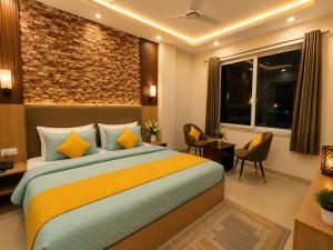 a bedroom with a bed and a brick wall at Palm Bliss A Luxury Hotel in Haridwār