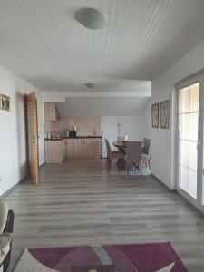 ein Wohnzimmer und eine Küche mit Tisch und Stühlen in der Unterkunft Apartman SELMA in Vogošća + 10 Fotos
