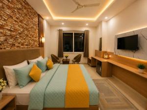 a hotel room with a bed and a tv at Palm Bliss A Luxury Hotel in Haridwār