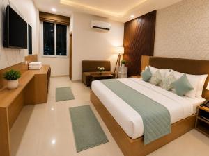a bedroom with a large bed and a television at Palm Bliss A Luxury Hotel in Haridwār
