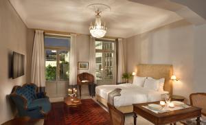 a bedroom with a bed and a table and a chandelier at Athenian Vintage Apartments in Athens
