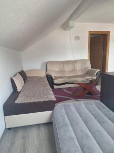 ein kleines Schlafzimmer mit einem Bett und einer Couch in der Unterkunft Apartman SELMA in Vogošća