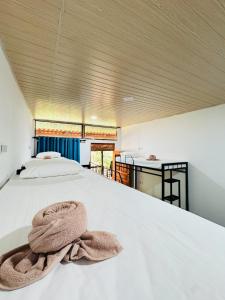 a bedroom with a bed with a towel on it at Glowhaven Hostel in Sigiriya