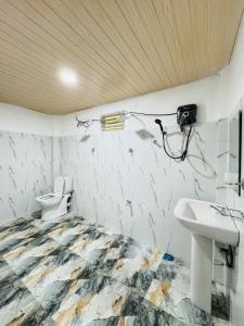 a bathroom with a toilet and a sink and a camera at Glowhaven Hostel in Sigiriya