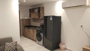 a kitchen with a black refrigerator and a washer at Luxury Studio, pool, Private beach & close to Airport in Hurghada