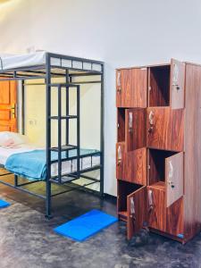 a room with two bunk beds and a dresser at Glowhaven Hostel in Sigiriya