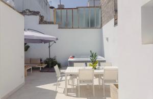 a white dining room with a white table and chairs at Ada&niní in Galatina
