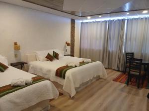 a hotel room with two beds and a window at Hotel Cristales De Sal in Uyuni +50 photos