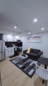 a living room with a black couch and a kitchen at Suite in Ambleton - Calgary in YYC