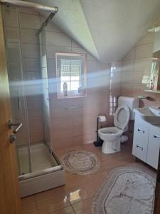 ein Badezimmer mit Dusche, Toilette und Waschbecken in der Unterkunft Apartman SELMA in Vogošća