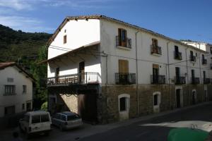 a large white building with cars parked in front of it at Casa Rural Restaurante Casino Munilla in Munilla