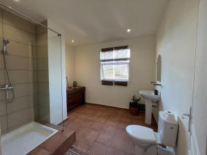 a bathroom with a shower and a toilet and a sink at Grande Maison Mandrosoa in Abohijanahary +10 photos