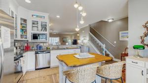 a kitchen with white cabinets and a wooden table at Rehoboth Crossing - 36983 Grindstone Ln in Rehoboth Beach +21 photos