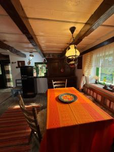 a dining room with a table with a plate on it at Căsuța Rustică in Muncelu Mare +17 photos