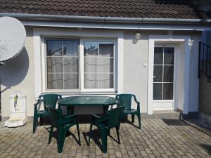 a green table and chairs in front of a house at Villa Ladver in Hévíz