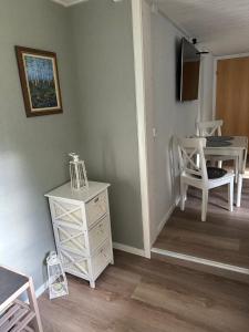 a living room with a white dresser and a table at Parkgatan in Vemdalen +2 photos