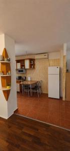 a kitchen with a table and a white refrigerator at Casa Melcilor in Mangalia +9 photos