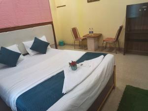 a bedroom with a large white bed with a table and chairs at Woohoo Hotels in Patna