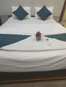 a large white bed with a plant on it at Woohoo Hotels in Patna +1 photo