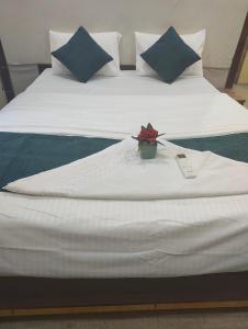 a white bed with a flower in a box on it at Woohoo Hotels in Patna