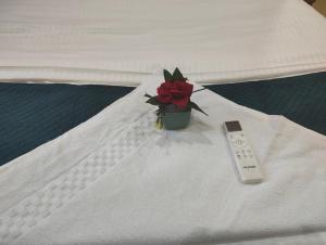 a remote control sitting on a bed next to a flower at Woohoo Hotels in Patna