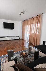 a living room with a tv and a couch and a table at Casa Melcilor in Mangalia