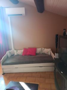 a bed with two red pillows in a room at Appartement in Courthézon