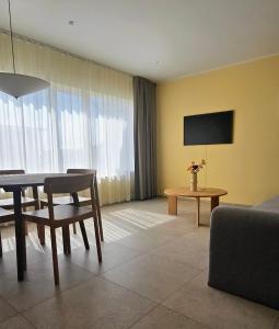 a living room with a table and a tv at Eldá apartments in Myvatn