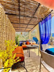 a patio with a table and chairs and a couch at Dar Besmellah in Chefchaouen