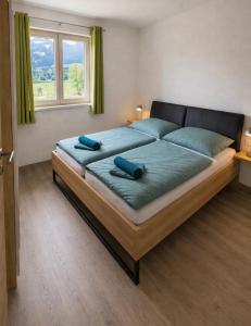 a bedroom with a large bed with two blue pillows on it at Apartment Kaiblingblick in Haus im Ennstal