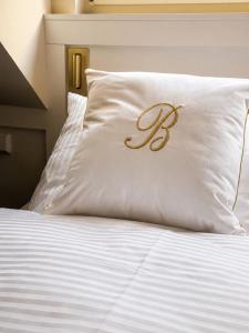 a white pillow with a letter on it on a bed at Büdel's Spessart Lounge in Lohr am Main
