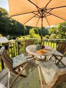 a table and chairs with an umbrella on a deck at Büdel's Spessart Lounge in Lohr am Main