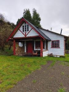 a small white house with a red door at Birloche in Pindapulli