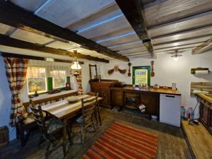 a dining room with a table and a kitchen at Căsuța Rustică in Muncelu Mare