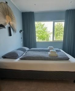 a bedroom with a large bed with a window at Eldá apartments in Myvatn